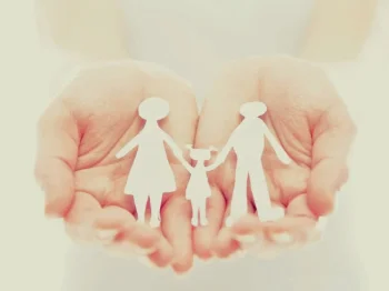 A family paper cut-out in a child's hands